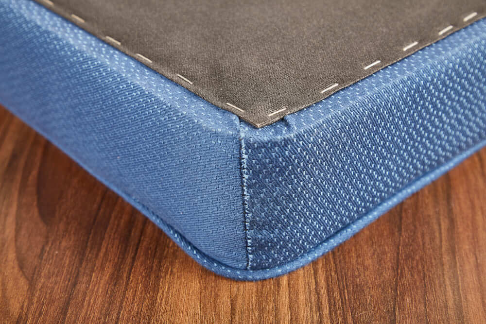corner of platform cushion showing seam, piping and stapled underlining fabric to backer board